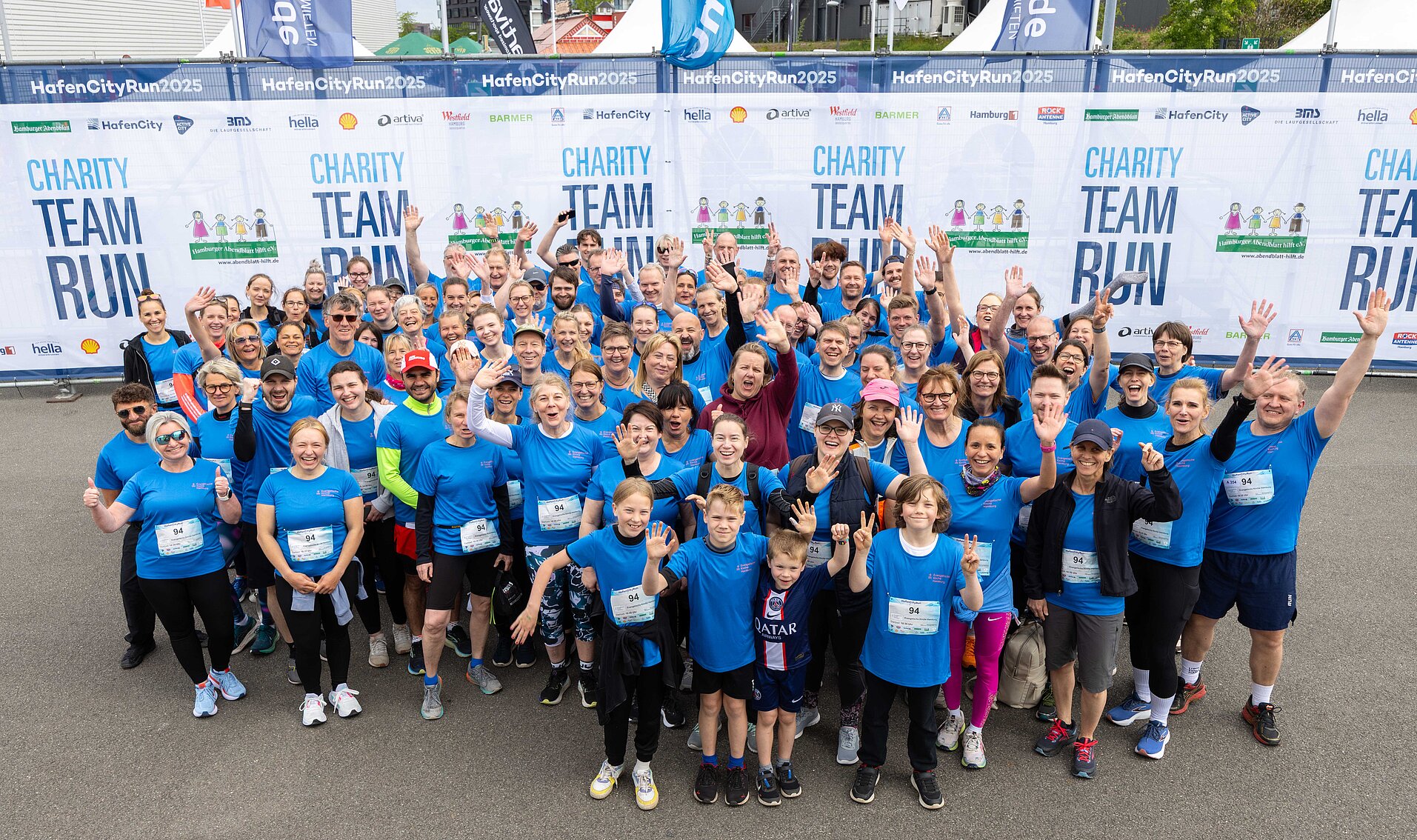 Foto einer jubelnden Gruppe aus Läuferinnen und Läufern beim Charity Team Run
